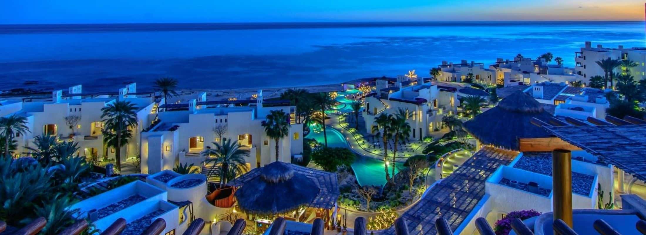 Las Ventanas at night time with pool and houses over looking the ocean