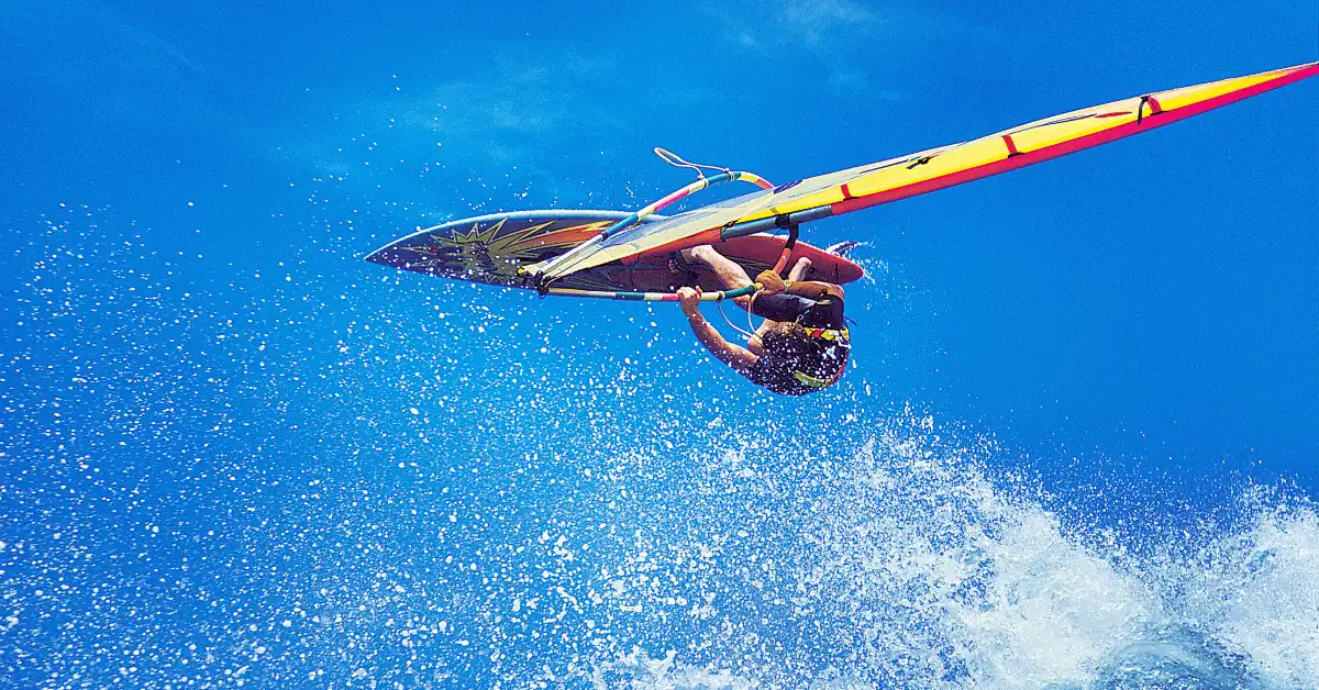 Windsurfer jumping clear of the water against a deep blue sky at La Ventana, Baja California Sur