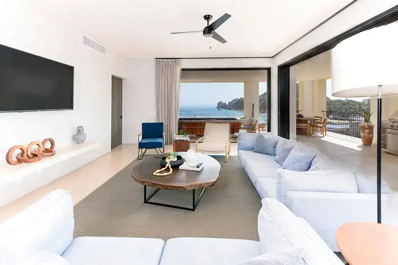 Open-plan living room with sliding glass doors opening onto a terrace overlooking the ocean