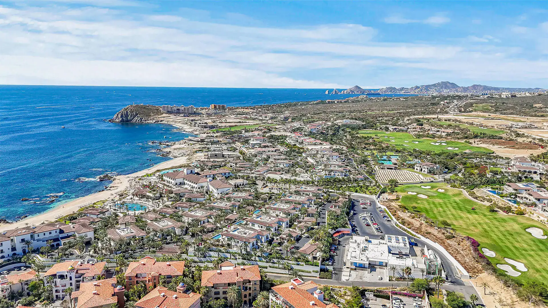 Aerial view of the Cabo Corridor coastline with luxury gated communities, championship golf course, and Land's End visible in the distance, Los Cabos, Baja California Sur, Mexico.