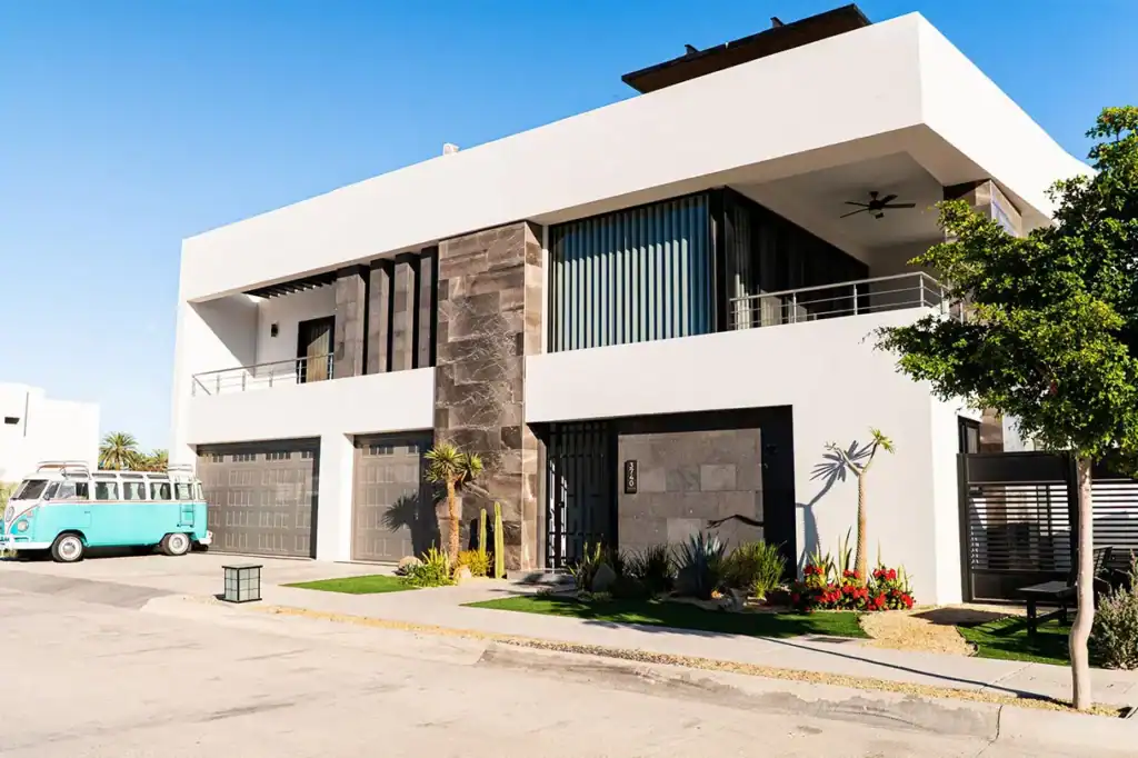 Modern luxury residential home with contemporary architecture, stone facade, and desert landscaping in La Paz, Baja California Sur, Mexico.