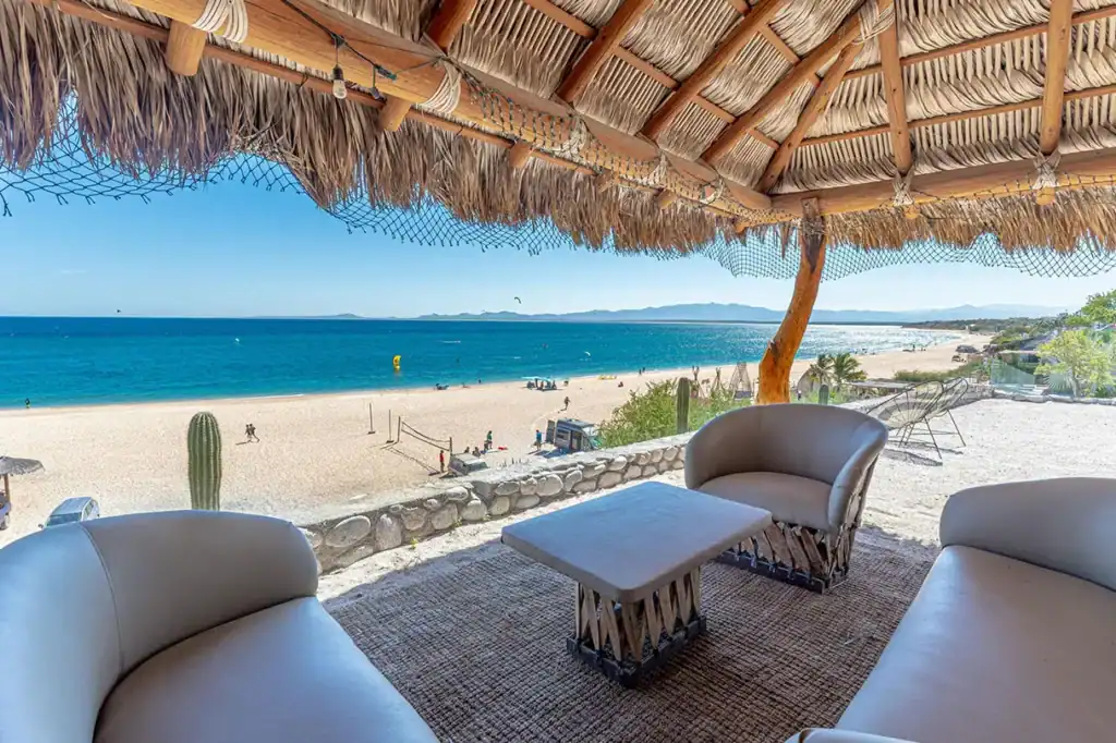 Palapa-shaded terrace with ocean view seating overlooking kiteboarding activity on the beach at La Ventana, Sea of Cortez, Baja California Sur, Mexico.