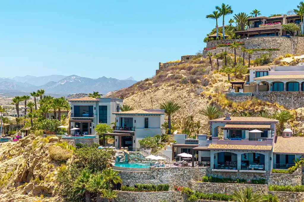 Luxury hillside villas and residences with infinity pools cascading down a rocky hillside in the San José Corridor, Los Cabos, Baja California Sur, Mexico.