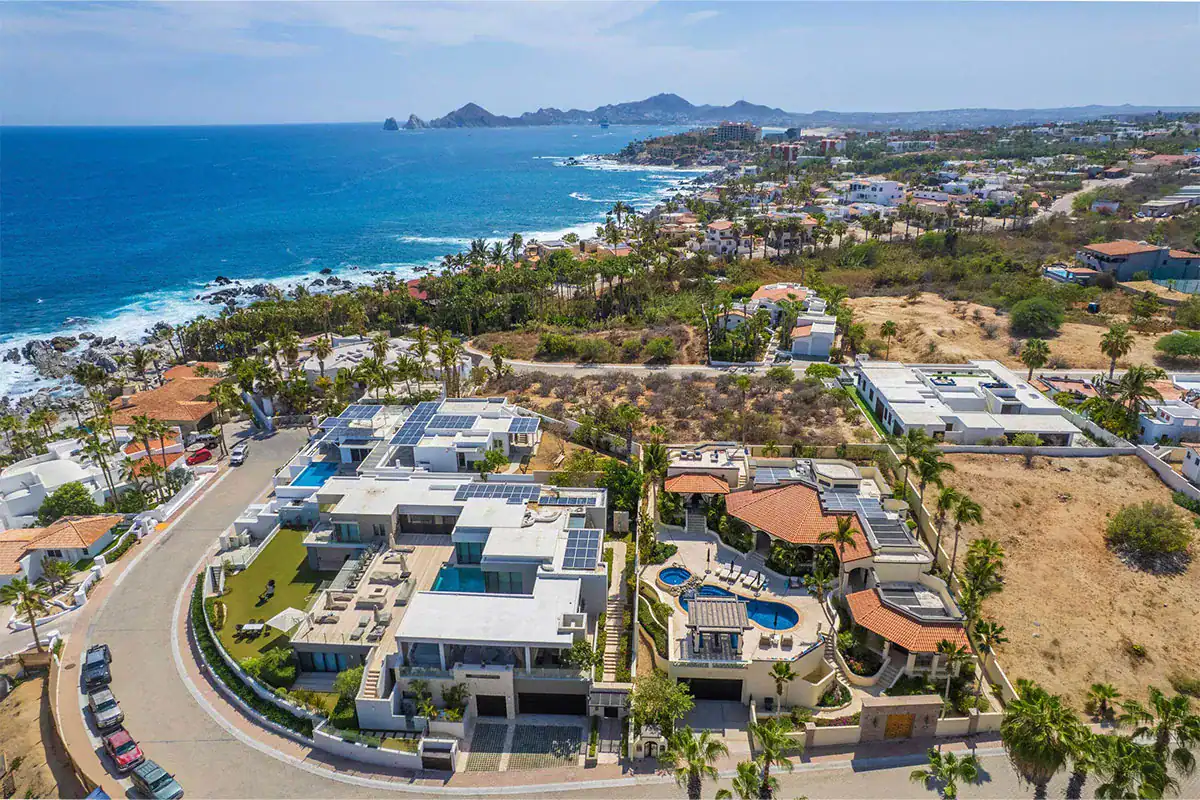 Aerial view of oceanfront villas, homes and open lots along the coast, showing the choice of condo, villa or land in Los Cabos