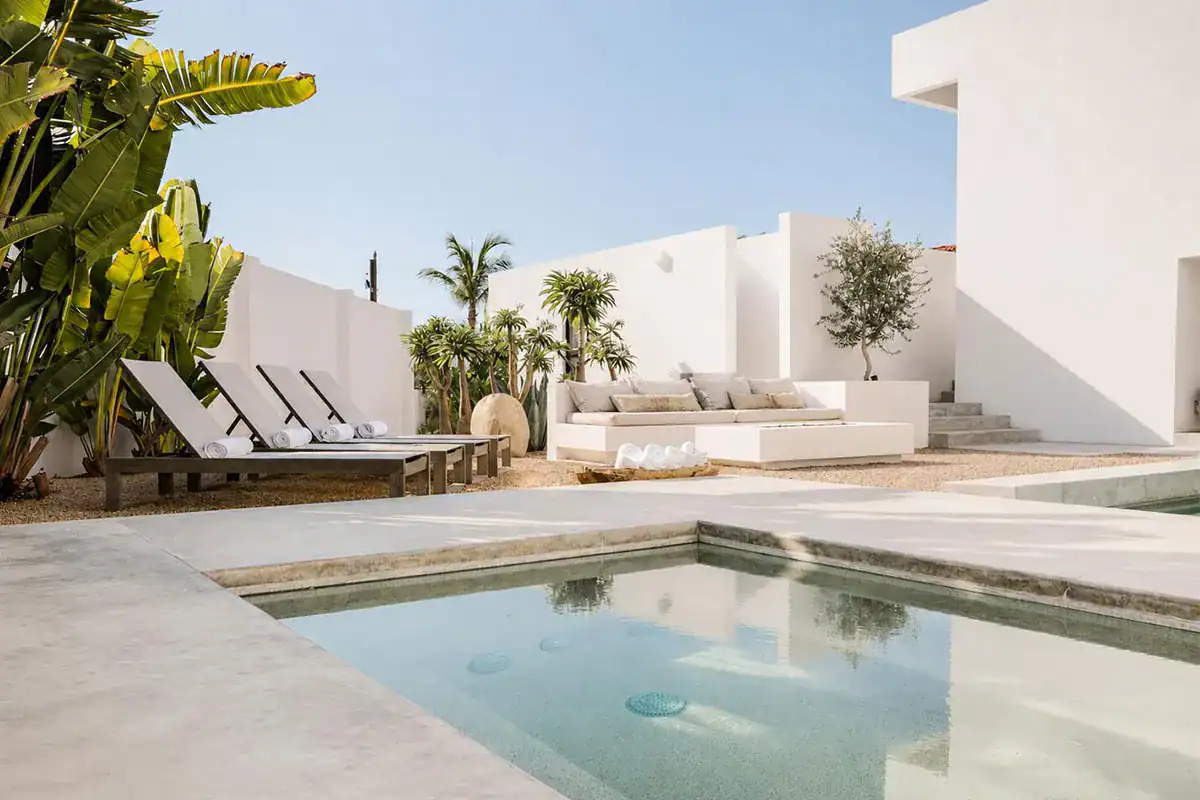 Modern white villa with a pool and sun loungers, illustrating closing costs in Los Cabos for a home buyer